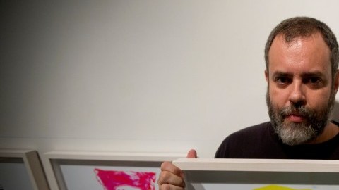 El fotógrafo venezolano Juan Toro posa para un retrato con su imagen de un paquete de harina en una galería de arte en Caracas, Venezuela en una fotografía del 12 de noviembre de 2015. La fotografía forma parte de la exposición "Desaparecidos" sobre productos básicos que enfrentan escasez en Venezuela. Toro trató de preservarlos en la memoria colectiva con su muestra. (Foto AP/Fernando Llano)