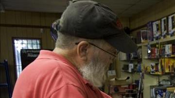 Un propietario de la tienda de armas vende un producto a un cliente.