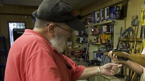Un propietario de la tienda de armas vende un producto a un cliente.