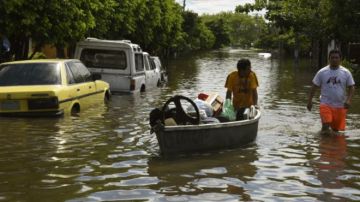 Los habitantes de un barrio de Asunción intentan recuperar algunos de sus bienes afectados por las inundaciones en Paraguay.