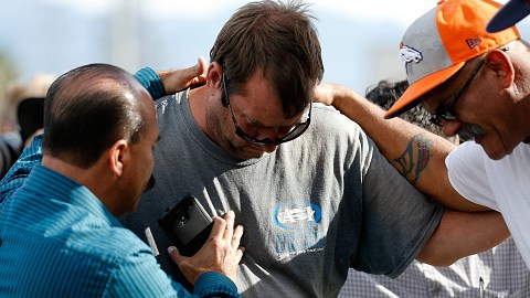 Un grupo de hombres se abrazan afuera del Inland Resource Center en San Bernardino, donde una pareja armada ultimó a 14 personas e hirió a muchas más. (Getty Images)