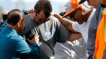 Un grupo de hombres se abrazan afuera del Inland Resource Center en San Bernardino, donde una pareja armada ultimó a 14 personas e hirió a muchas más. (Getty Images)