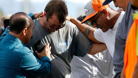 Un grupo de hombres se abrazan afuera del Inland Resource Center en San Bernardino, donde una pareja armada ultimó a 14 personas e hirió a muchas más. (Getty Images)