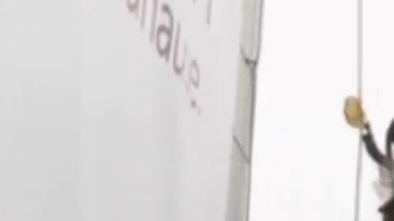 El trabajo de instalar y reemplazar anuncios en rascacielos es de alto riesgo.