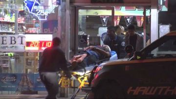 Uno de los empleados heridos es sacado de la tienda en camilla.