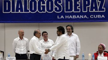 El jefe de la delegación de paz del Gobierno colombiano, Humberto de la Calle (c-i), y el segundo jefe de las FARC y líder de los delegados de esta guerrilla, Luciano Marín (c-d), alias "Iván Márquez, se saludan .