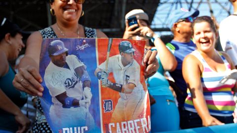 Una aficionada muestra un cartel de los beisbolistas Manuel Pui y Miguel Cabrera durante una clase práctica de beisbolistas de Grandes Ligas a niños cubanos en La Habana.