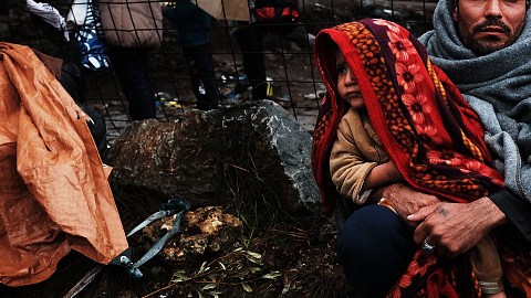 Un hombre y su niña, refugiados de Siria, se cobijan como pueden en la isla de Lesbos, en Grecia