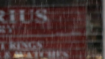 Personas intentan protegerse de la fuerte lluvia en el centro de Los Ángeles. / AURELIA VENTURA