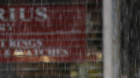 Personas intentan protegerse de la fuerte lluvia en el centro de Los Ángeles. / AURELIA VENTURA