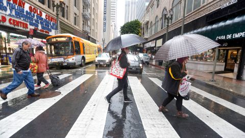 Angelinos se protegen de la lluvia en el centro de la ciudad. /AURELIA VENTURA