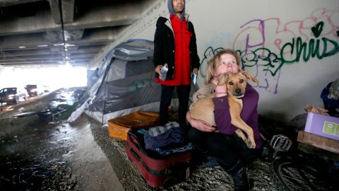 Cristine Owens con su perro "Charlie" reciben asistencia por parte de agentes de Sheriff. Estos indigentes viven a la orilla del río San Gabriel, donde están amenazados por las lluvias. /AURELIA VENTURA
