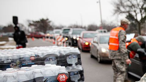 Un especialista de la Guardia Nacional carga agua embotellada para los vecinos de Flint.