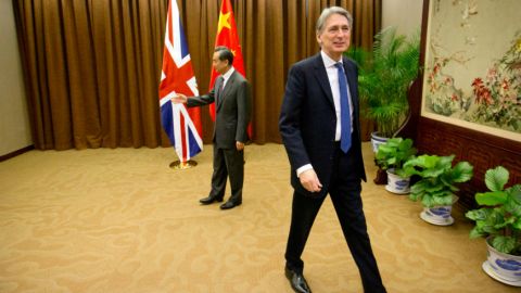 British Foreign Secretary Philip Hammond, right, walks away after shaking hands with Chinese Foreign Minister Wang Yi