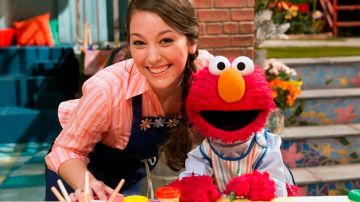 Suki López en su personaje de Nina en "Sesame Street" junto a Elmo.