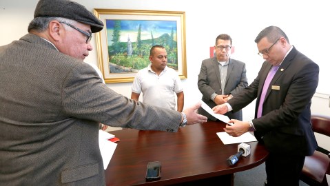 Salvador Sanabria, de El Rescate, entrega la petición de ayuda para los menores al vicecónsul de El Salvador en Los Ángeles, Julio Calderon. / AURELIA VENTURA