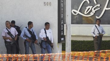 Policías resguardan la zona donde fueron ejecutados a balazos tres efectivos de la Policía de Tlaquepaque en Jalisco.