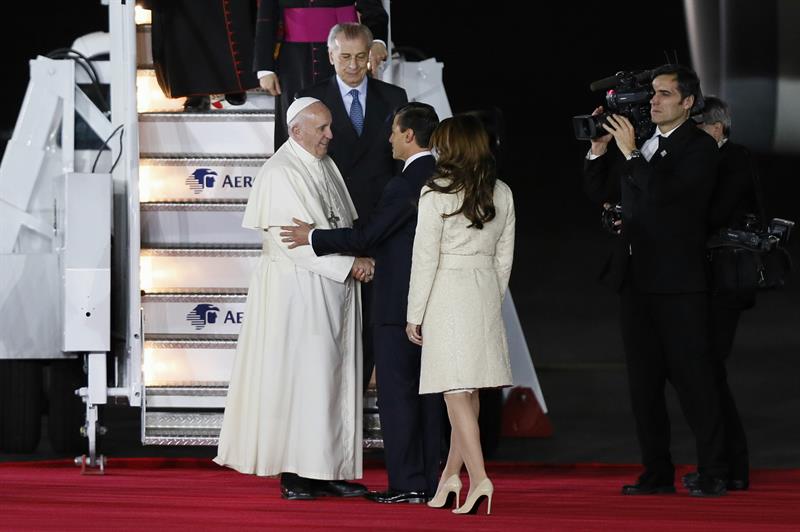 El papa Francisco conversa con el presidente mexicano, Enrique Peña Nieto (d), y la primera dama, Angélica Rivera (i), el 12 de febrero de 2016, en el hangar presidencial del Aeropuerto Internacional de Ciudad de México.