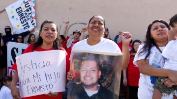 Juana Díaz (i) y Selene Canepa (c) protestan en la esquina donde Ernesto Canepa fue baleado hace un año por agentes del Departamento de Policía de Santa Ana.