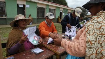 Una jurado electoral aimara muestra la papeleta de votación en la localidad de Patamanta