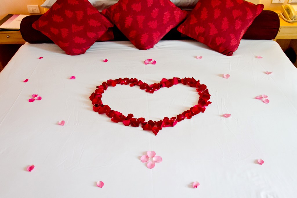 Con los pétalos de las rosas rojas puedes crear un corazón muy alusivo y decorativo sobre la cama.