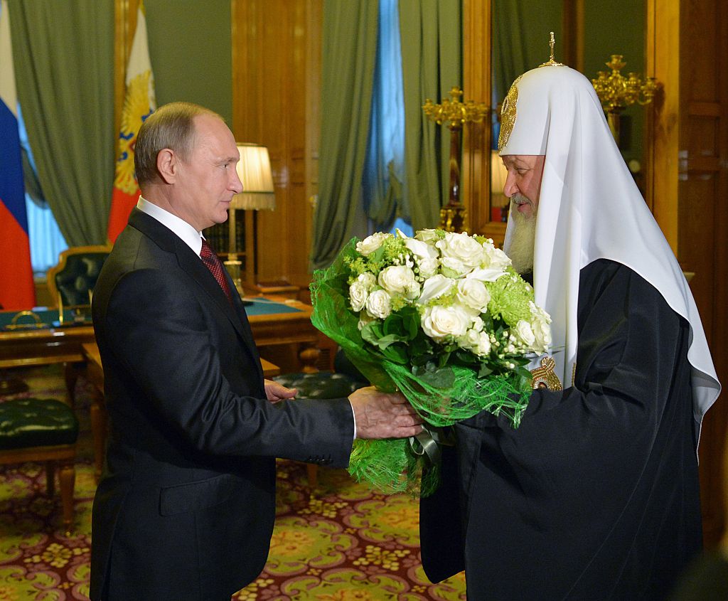El presidente ruso Vladimir Putin le regala flores al Patriarca ortodoxo Kiril con motivo del 69 cumpleaños del patriarca, celebrado en el Kremlin de Moscú, el 25 de noviembre de 2015. 