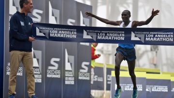 El keniano Weldon Kirui cruza la meta para ganar el maratón de LA con el alcalde Eric Garcetti como testigo. Otros tres corredores de Kenia le siguieron en los primeros sitios.
