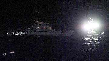 A US Coast Guard cutter (L) searches, with the ass