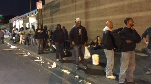 Durante horas los desamparados hacen fila por la cena que les lleva cada noche de lunes a viernes el grupo de voluntarios de Monday Night Mission. (Araceli Martínez/La Opinión).