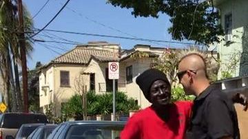 Elvis Summers  y una mujer sin hogar, frente a una de las 'casitas'  temporarias.