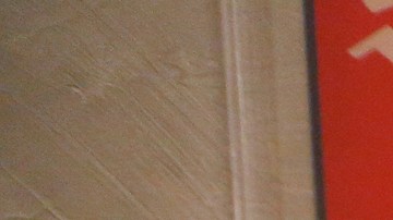 Robert Clary, un sobreviviente del holocausto, posa junto a un afiche Nazi que es parte de la exhibición en la biblioteca. / (Foto: Aurelia Ventura/La Opinion)