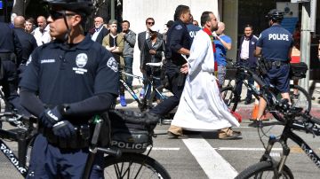Policías se llevan esposado al fraile Chris Ponnet, del Centro Camillus Católico Romano, tras su arresto por desobediencia civil en Los Ángeles, California.