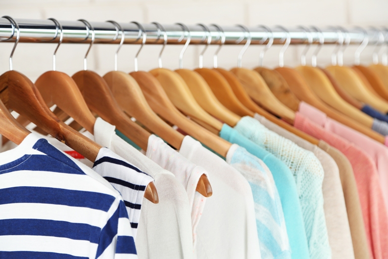 Cuelga la ropa en el perchero, dividida por categorías y agrupada por estilo y colores.