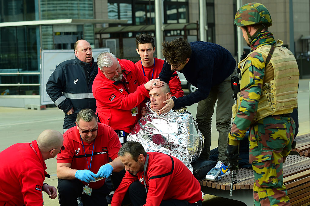 Víctima recibe primeros auxilios de rescatistas cerca de la estación del metro de Maalbeek en Bruselas, tras el atentado a esta estación cercana a los edificios de la Unión Europea que causó varias muertes y centenares de heridos. 