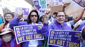 Celebración después que el gobernador de California Jerry Brown firma en ley el incremento del salario mínimo a 15 dólares por hora, durante una ceremonia en el centro de Los Ángeles.