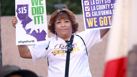 Empleados celebran después que el gobernador de California Jerry Brown firma en ley el incremento del salario mínimo a 15 dólares por hora, durante una ceremonia en el centro de Los Ángeles. La propuesta de aumentar el salario mínimo en California a $15 por hora para el año 2022 fue aprobada ayer por la legislatura estatal. (Foto: Aurelia Ventura/La Opinion)