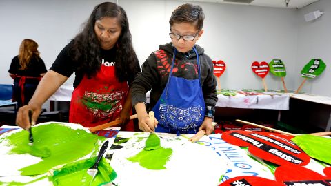 Carolina Moran y su hijo Angel Gallegos, ayudan a preparar los carteles para la marcha del 1 de Mayo en Los Ángeles.
