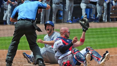 Clayton Kershaw reacciona tras ser puesto out en home por el catcher de los Bravos, Tyler Flowers.