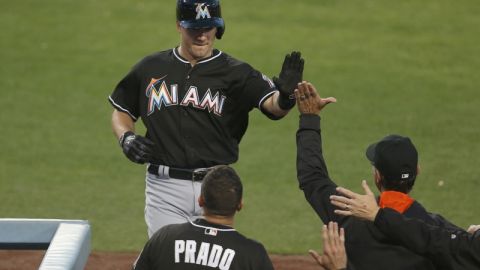 J.T. Realmuto de los Miami Marlins festeja un jonrón con su manager Don Mattingly y con Martin Prado.