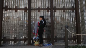 Karen Herrera con su bebé  habla con su familia en la frontera EEUU-México el 30 de abril de 2016 en San Diego, California.