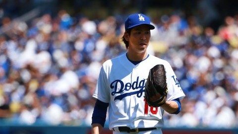 El pitcher Kenta Maeda, de los Dodgers, intercambia opiniones con el catcher A.J. Ellis en la primera entrada del juego inauugural en el Dodger Stadium.