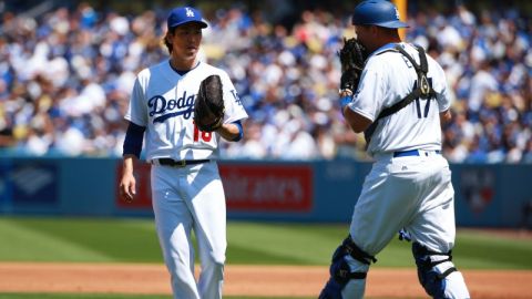 El pitcher Kenta Maeda, de los Dodgers, intercambia opiniones con el catcher A.J. Ellis en la primera entrada del juego inauugural en el Dodger Stadium.