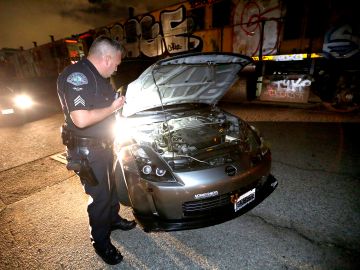 El sargento Jessee Garcia del LAPD revisa un auto para ver si ha sido modificado y es usado para carreras ilegales de auto.