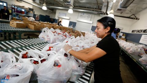 Danubia Alarcon, voluntaria de MEND, ayuda a preparar bolsas de comida para distribuir entre personas necesitadas. (Aurelia Ventura/La Opinion)