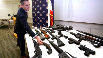 El alcalde Eric Garcetti inspecciona algunas de las armas entregadas. (Aurelia Ventura/La Opinion)