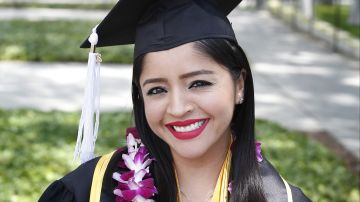 La estudiante 'Dreamer' Sandra López muestra orgullosa la toga y el birrete que portará en su graduación de la Universidad Estatal de California Long Beach. /(Aurelia Ventura/ La Opinion)