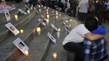 Varias personas encienden velas en el Ángel de la independencia en Ciudad de México, en memoria de los 49 niños que perdieron la vida en el incendio ocurrido en la guardería ABC de Hermosillo.