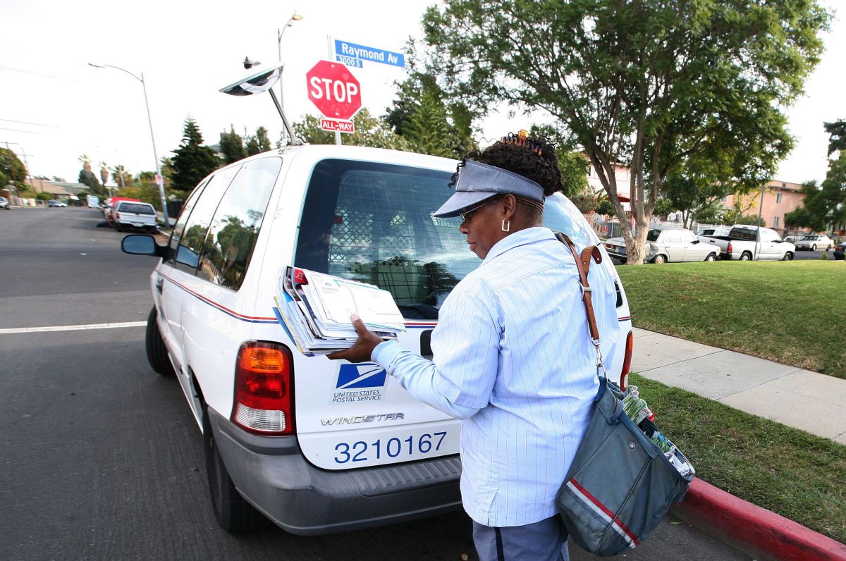 Una empleada postal entrega correo en el sur de Los Ángeles.