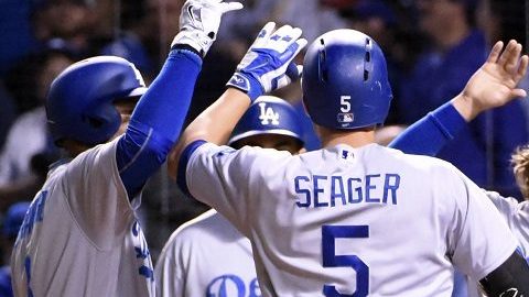 Corey Seager es felicitado por sus compañeros tras pegar jonrón ante Chicago en la novena entrada.