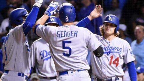 Corey Seager es felicitado por sus compañeros tras pegar jonrón ante Chicago en la novena entrada.